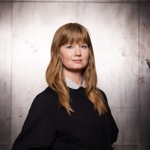 Julia Brinker posiert selbstbewusst vor einer modernen Wand, repräsentiert Vielfalt und Engagement im Fußball.