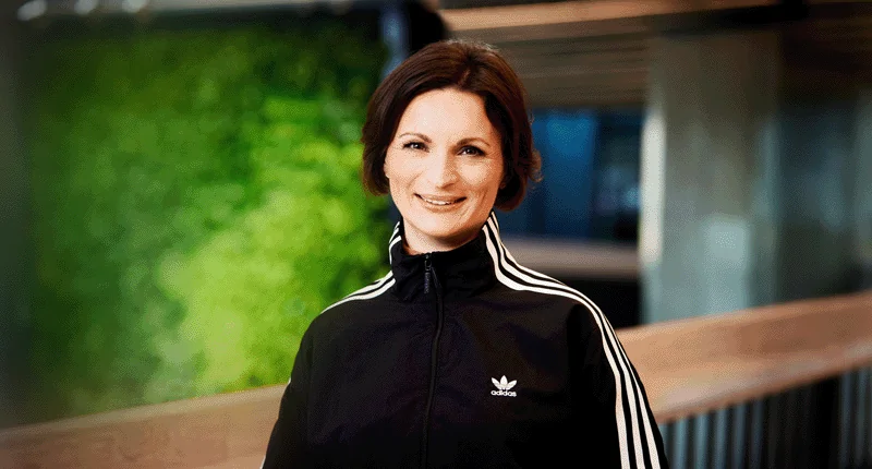 Marina Mogus steht in sportlicher Kleidung und lächelt, während sie eine inklusive Zukunft im Fußball fördert.