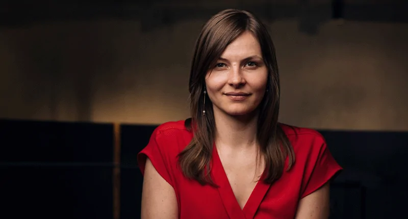 Marthe-Victoria-Lorenz in einem roten Kleid, strahlend und selbstbewusst, symbolisiert Fortschritt im Fussball.
