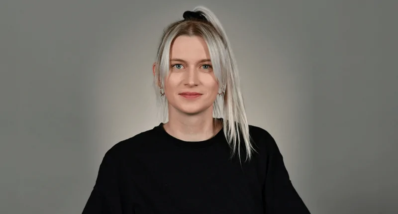 Sabrina Schäfer steht lächelnd vor einem neutralen Hintergrund und repräsentiert die Vielfalt im Fußball.