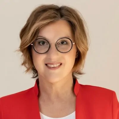 Katrin Prüfig lächelt in einem roten Blazer und setzt sich für Vielfalt und Veränderung im Fußball ein.